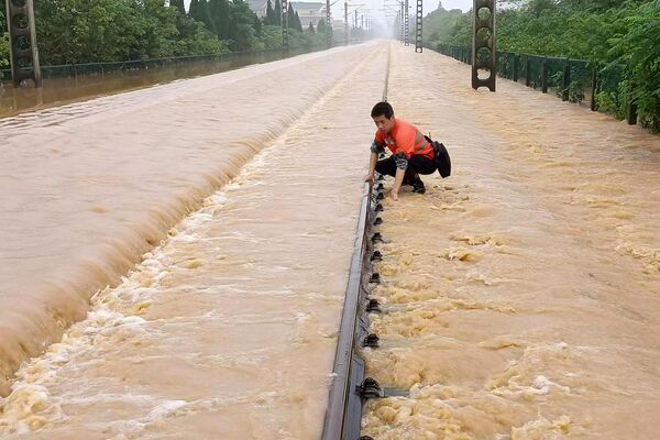 Công nhân đường sắt kiểm tra đường tàu bị ngập sau trận mưa lớn ở Trung Quốc. - Sputnik Việt Nam