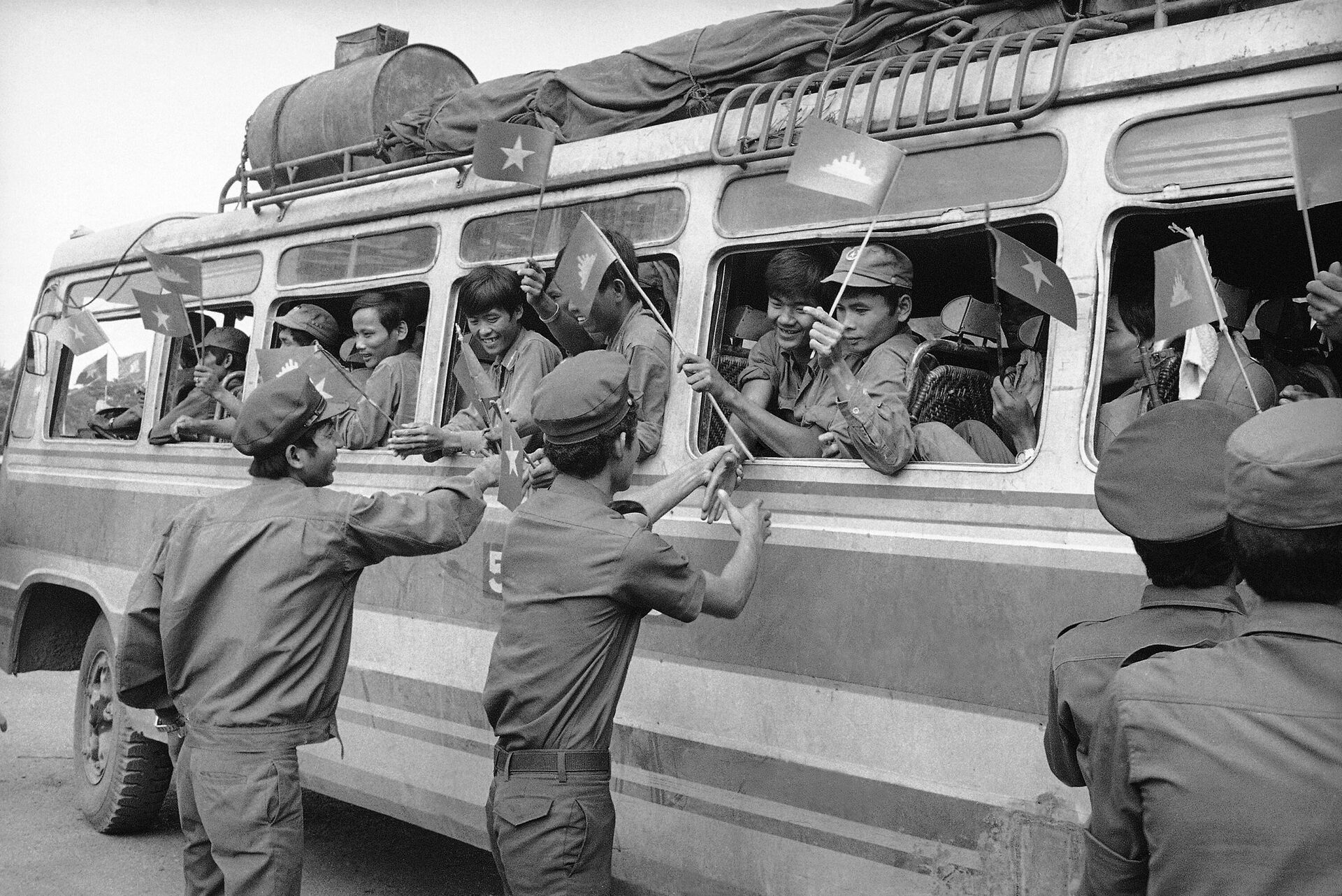 Các binh sĩ Campuchia chào tạm biệt quân đội Việt Nam trên xe buýt khi họ rời Phnom Penh, Campuchia, 1982 - Sputnik Việt Nam, 1920, 24.06.2022