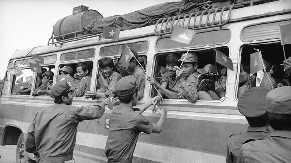 Các binh sĩ Campuchia chào tạm biệt quân đội Việt Nam trên xe buýt khi họ rời Phnom Penh, Campuchia, 1982 - Sputnik Việt Nam
