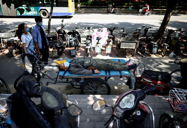 Người đàn ông đeo khẩu trang ngủ trên giường ba bánh ở Bắc Kinh - Sputnik Việt Nam