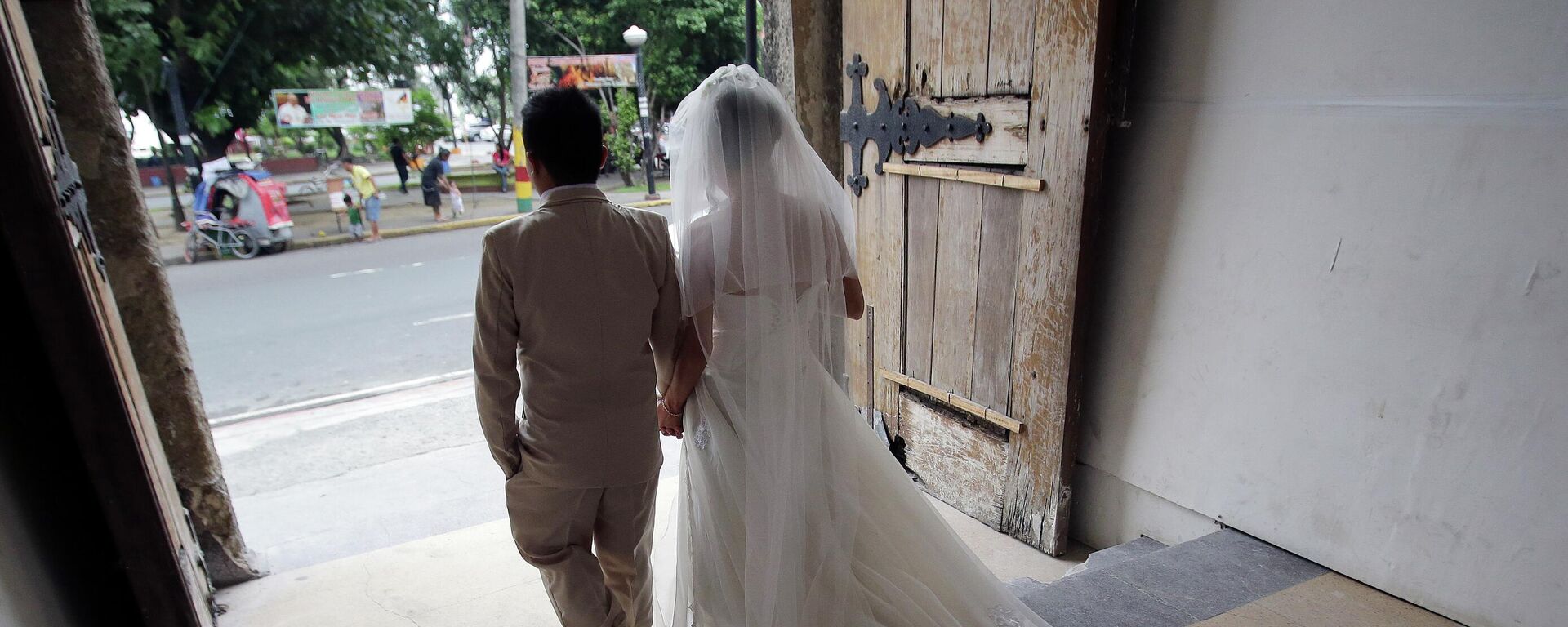 Cặp đôi mới cưới sau đám cưới của họ tại một nhà thờ Công giáo ở Manila, Philippines - Sputnik Việt Nam, 1920, 07.07.2022