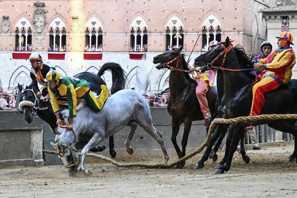 Tay đua người Ý Stefano Piras ngã ngựa vì khi xuất phát sai trong cuộc đua Palio di Siena ở Siena, Tuscany. - Sputnik Việt Nam