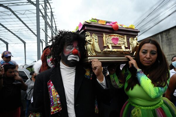 Những chú hề Guatemala cùng người thân khiêng quan tài chứa thi thể của Joselin Chacon ở Amatitlán. - Sputnik Việt Nam