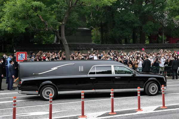 Chiếc xe chở thi hài của cựu Thủ tướng Nhật Bản Shinzo Abe rời khỏi chùa Jojoji sau lễ tang của ông ở Tokyo vào thứ Ba, ngày 12 tháng 7 năm 2022. - Sputnik Việt Nam