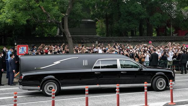 Chiếc xe chở thi hài của cựu Thủ tướng Nhật Bản Shinzo Abe rời khỏi chùa Jojoji sau lễ tang của ông ở Tokyo vào thứ Ba, ngày 12 tháng 7 năm 2022. - Sputnik Việt Nam