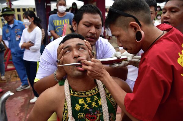 Người đàn ông đâm thủng má tại cuộc diễu hành thường niên tôn vinh nữ thần đền Gow Lengchi, ở tỉnh Narathiwat, miền nam Thái Lan, ngày 13 tháng 7 năm 2022. - Sputnik Việt Nam