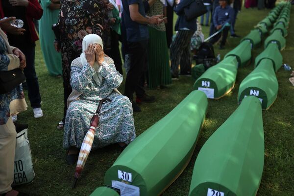 Người dân Bosnia - Bakhta Aldzic theo đạo Hồi để tang bên cạnh quan tài của chồng ở Potocari. - Sputnik Việt Nam