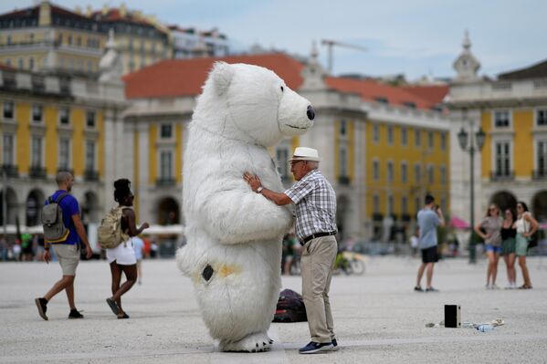 Người đàn ông nói chuyện với một người ăn mặc như gấu Bắc Cực tại Quảng trường Comercio ở Lisbon. - Sputnik Việt Nam