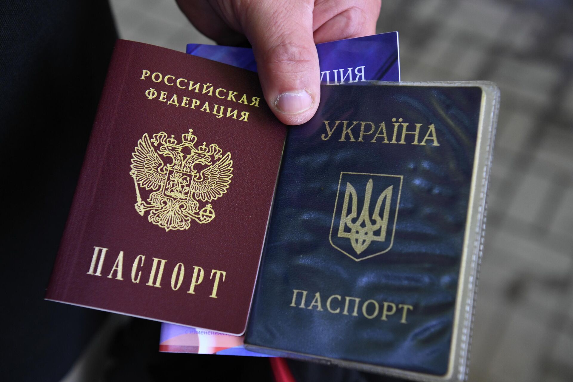 Hộ chiếu của Nga và Ukraina trong tay một người dân Berdyansk. - Sputnik Việt Nam, 1920, 20.07.2022