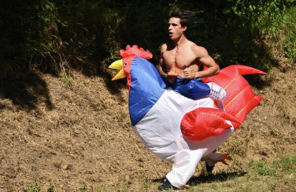 Một khán giả ăn mặc như con gà trống chạy dọc bên đường trong chặng 15 của «Tour de France» lần thứ 109 ở miền nam nước Pháp. - Sputnik Việt Nam
