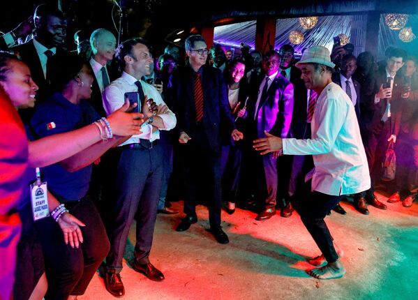 Tay vợt Pháp Yannick Noah khiêu vũ bên cạnh Tổng thống Pháp Emmanuel Macron trong bữa tiệc ở Etoudi, Yaounde, Cameroon. - Sputnik Việt Nam