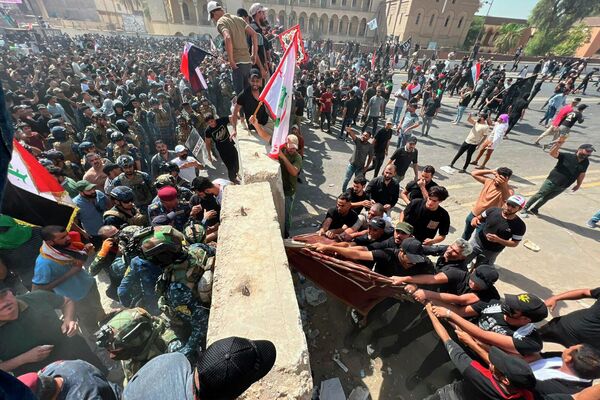 Những người ủng hộ chính trị gia Iraq Muqtada al-Sadr phá bỏ hàng rào bê tông trên con đường tới «Vùng Xanh» ở Baghdad. - Sputnik Việt Nam