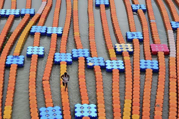 Người chèo thuyền theo cầu tàu nổi làm bằng nhựa hình khối dọc theo bờ sông Hằng ngập lụt nước dâng cao sau trận mưa lớn ở Allahabad. - Sputnik Việt Nam
