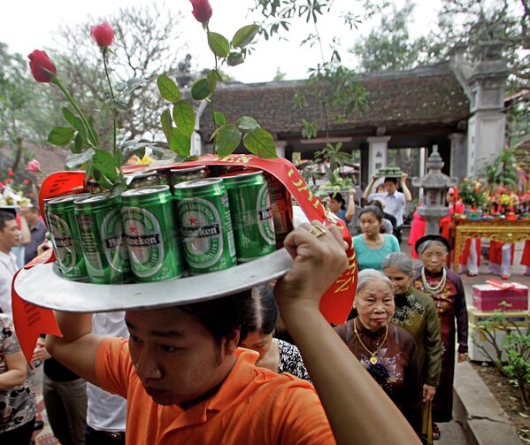 Một người đàn ông xếp lon bia lên bàn thờ trong ngày lễ ở chùa Kim Liên, Hà Nội, Việt Nam - Sputnik Việt Nam
