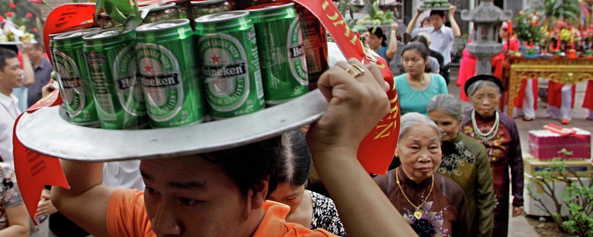 Мужчина несет банки пива  к алтарю во время фестиваля Kim Lien Temple в Ханое, Вьетнам - Sputnik Việt Nam, 1920, 05.08.2022