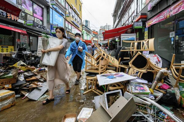 Người đi bộ băng qua những mảnh vỡ tại Chợ Namseong lịch sử của Seoul. - Sputnik Việt Nam