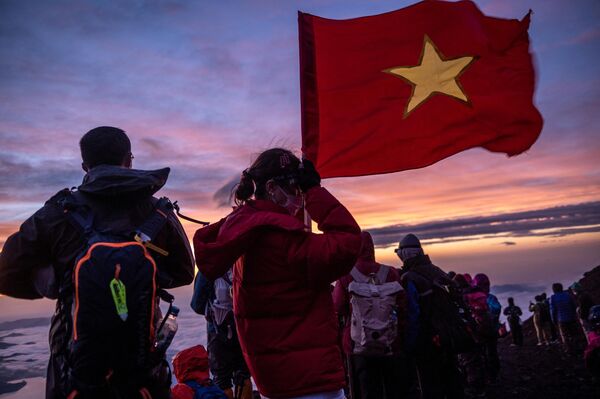 Du khách cầm cờ Việt Nam khi mọi người ngắm bình minh từ đỉnh núi Phú Sĩ. - Sputnik Việt Nam