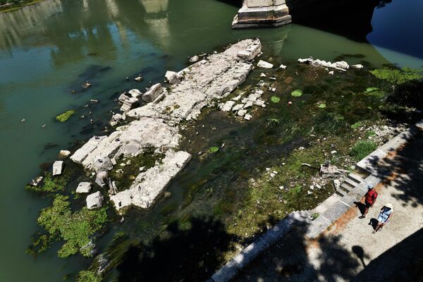 Mực nước thấp ở sông Tiber gần cầu Vittorio Emanuele II, cho thấy một cây cầu cổ được xây dựng dưới thời hoàng đế La Mã Nero ở Roma. - Sputnik Việt Nam