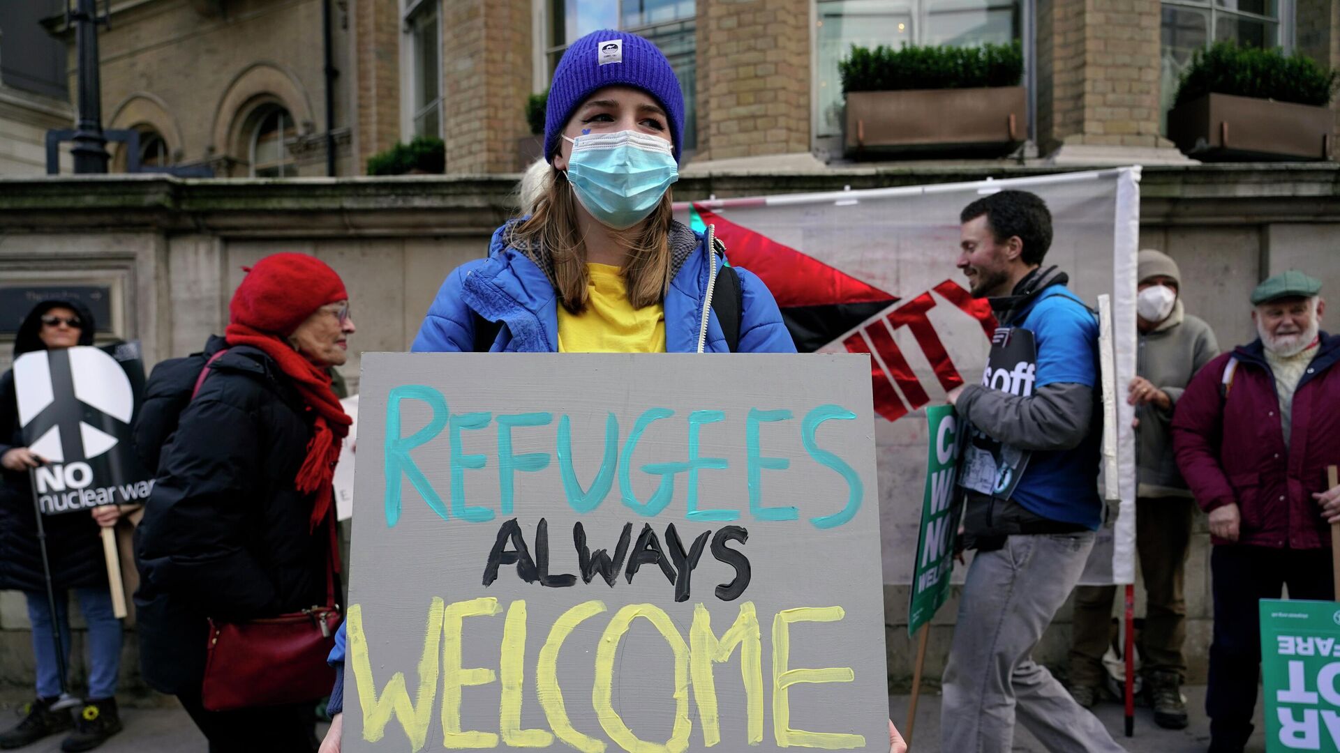 Một người biểu tình cầm biểu ngữ đọc Người tị nạn luôn được chào đón ở London - Sputnik Việt Nam, 1920, 14.09.2023