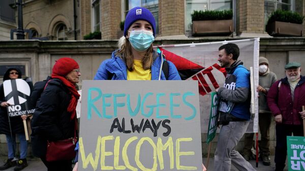 Một người biểu tình cầm biểu ngữ đọc Người tị nạn luôn được chào đón ở London - Sputnik Việt Nam