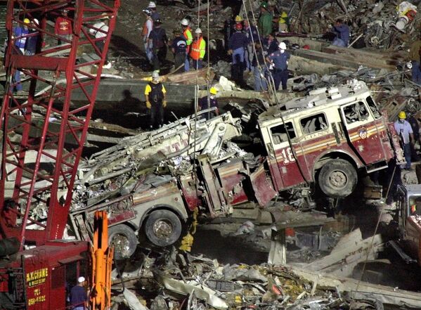 Kéo xe cứu hỏa ra khỏi đống đổ nát sau vụ tấn công khủng bố vào Trung tâm Thương mại Thế giới ở Hoa Kỳ. - Sputnik Việt Nam
