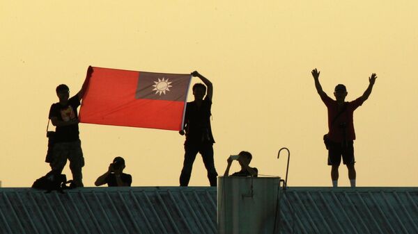 Người dân trên sân thượng trưng bày quốc kỳ Đài Loan trong cuộc tập trận của máy bay chiến đấu Đài Loan ở Gia Nghĩa, Đài Loan - Sputnik Việt Nam