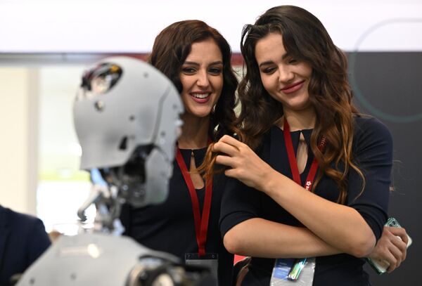 Các cô gái đang quan sát robot quảng bá dịch vụ &quot;Alex&quot; tại Diễn đàn Kinh tế Phương Đông ở Vladivostok. - Sputnik Việt Nam