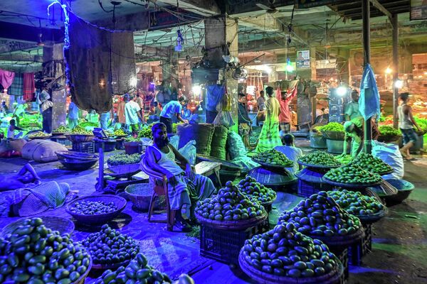 Người bán hàng đợi khách hàng tại chợ đầu mối rau củ ở Dhaka, Bangladesh. - Sputnik Việt Nam