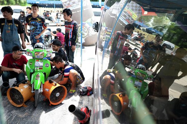 Thợ máy Thái Lan làm việc trên một chiếc mô tô đã được sửa đổi trong cuộc đua NGO Street Drag Race ở tỉnh Chonburi, Thái Lan. - Sputnik Việt Nam