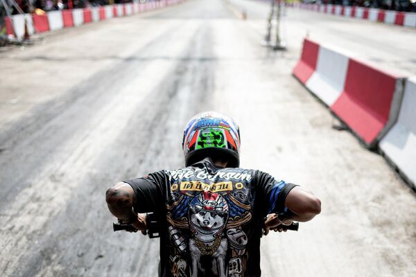 Tay đua Thái Lan lái chiếc mô tô đã được sửa đổi, mình trong cuộc đua NGO Street Drag Race ở tỉnh Chonburi, Thái Lan. - Sputnik Việt Nam