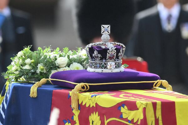 Quan tài Nữ hoàng Elizabeth II, được trang trí theo Tiêu chuẩn Hoàng gia và Vương miện Nhà nước Hoàng gia, được vận chuyển trên cỗ xe đội quân Kỵ binh - Pháo binh Hoàng gia từ Cung điện Buckingham đến Cung điện Westminster ở Luân Đôn. - Sputnik Việt Nam