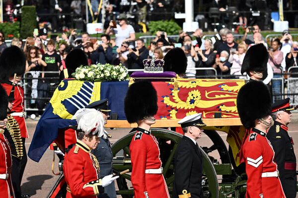 Quan tài Nữ hoàng Elizabeth II, được trang trí bằng Tiêu chuẩn Hoàng gia và Vương miện Hoàng gia, được nhìn thấy trong đám rước từ Cung điện Buckingham đến Cung điện Westminster ở London. - Sputnik Việt Nam