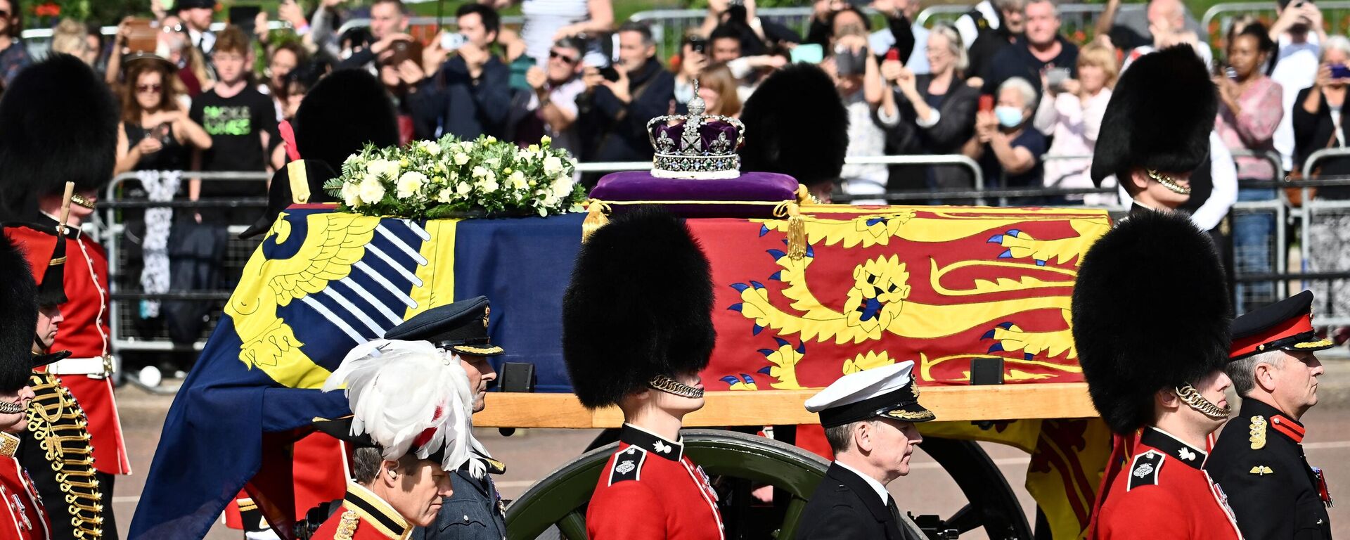 Quan tài  Nữ hoàng Elizabeth II, được trang trí bằng Tiêu chuẩn Hoàng gia và Vương miện Hoàng gia, được nhìn thấy trong đám rước từ Cung điện Buckingham đến Cung điện Westminster ở London. - Sputnik Việt Nam, 1920, 19.09.2022