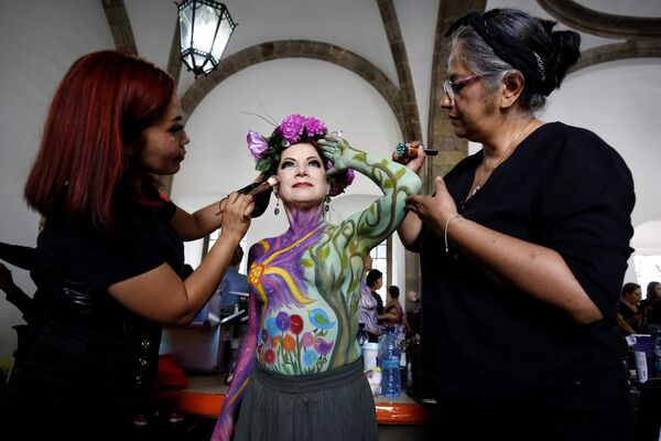 Hoạ sĩ vẽ màu lên thân hình người phụ nữ vừa chiến thắng căn bệnh ung thư vú trong khuôn khổ sự kiện «A brushstroke for life» ở Guadalajara, Mexico. - Sputnik Việt Nam