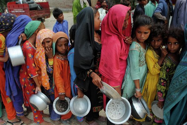 Cư dân các khu vực bị lũ lụt chờ phân phát thực phẩm từ Quỹ Saylani Welfare Trust ở Lal Bagh tỉnh Sindh thuộc Pakistan. - Sputnik Việt Nam