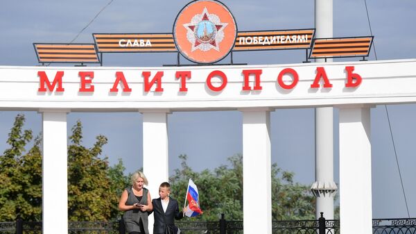 Một phụ nữ với một đứa trẻ trên Quảng trường Chiến thắng ở Melitopol. - Sputnik Việt Nam