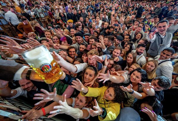 Thanh niên tới hưởng bia miễn phí tại một lều bia trong ngày khai mạc Lễ hội Bia Oktoberfest lần thứ 187 ở Munich, Đức. - Sputnik Việt Nam