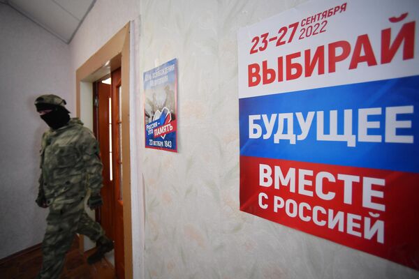 Thành viên nhóm tình nguyện tại một điểm bỏ phiếu  trưng cầu dân ý về việc gia nhập vùng Zaporozhye vào Nga ở Melitopol - Sputnik Việt Nam