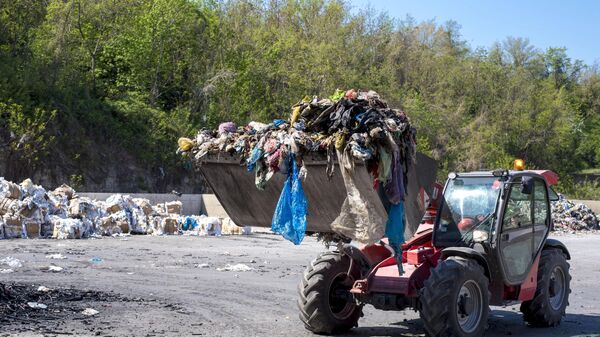 Máy xúc lật vận chuyển rác thải sinh hoạt đến nhà máy tái chế - Sputnik Việt Nam