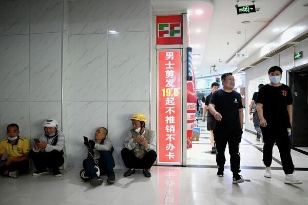 Các nhân viên giao hàng nghỉ giải lao tại một khu ẩm thực ở Bắc Kinh. - Sputnik Việt Nam