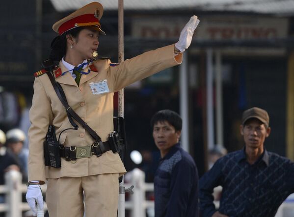Nữ cảnh sát điều khiển phương tiện giao thông tại ngã tư ở trung tâm Hà Nội. - Sputnik Việt Nam
