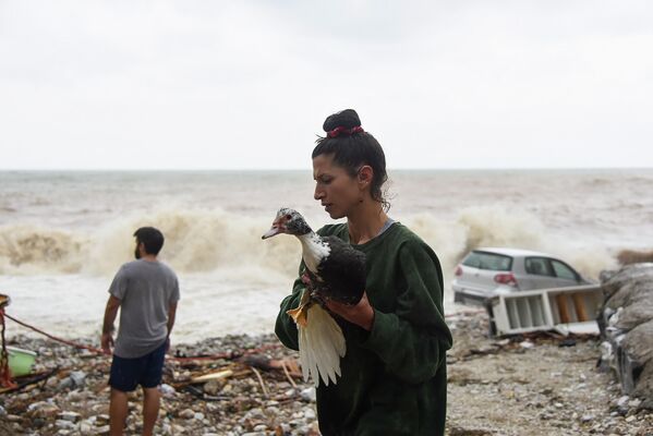 Người phụ nữ cứu một con chim trên bãi biển sau cơn giông và mưa rào ở đảo Crete, Hy Lạp. - Sputnik Việt Nam