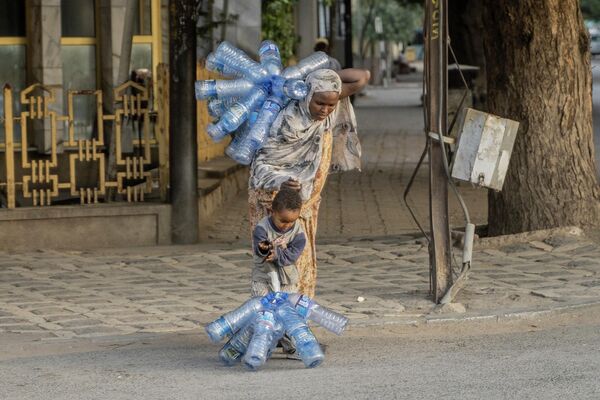 Cô gái với cô bé mang chai nhựa rỗng ở Dawa Dawa, Ethiopia. - Sputnik Việt Nam