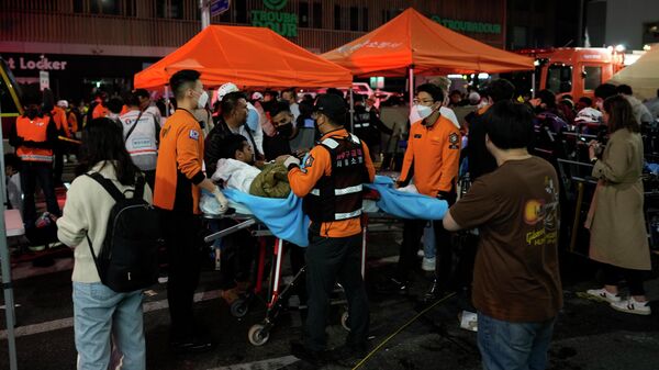 Lực lượng cứu hộ Seoul giúp các nạn nhân và đưa người chết ra khỏi đường phố, nơi trong lễ hội Halloween, hàng chục trái tim của người dân đã ngừng đập vì một vụ giẫm đạp, Hàn Quốc - Sputnik Việt Nam