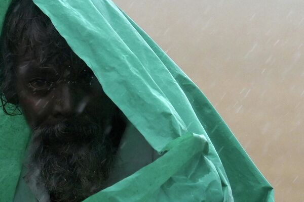 Người đàn ông khoác ni lông trong mưa gió mùa ở Chennai, Ấn Độ - Sputnik Việt Nam