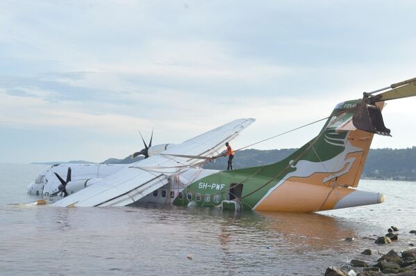 Nhân viên cứu hộ buộc tời để kéo chiếc máy bay phản lực Precision Air bị rơi ở Bukoba. - Sputnik Việt Nam