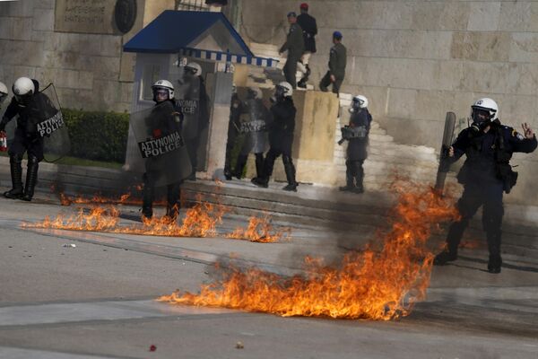 Các sĩ quan cảnh sát trên nền ngọn lửa từ chai đựng chất cháy trong cuộc biểu tình bên ngoài trụ sở Quốc hội Hy Lạp ở Athens. - Sputnik Việt Nam