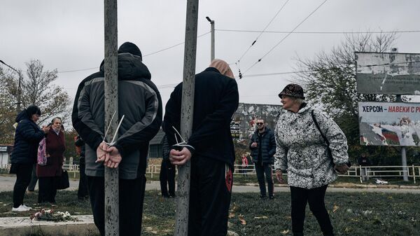 Cư dân Kherson, bị trói tay vào cột điện trên một trong những con đường của thành phố - Sputnik Việt Nam