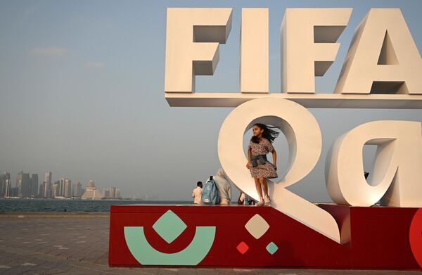 Bé gái bên biểu tượng FIFA World Cup ở Doha. - Sputnik Việt Nam