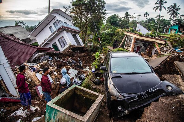 Dân làng thu dọn đồ đạc từ những ngôi nhà bị hư hại sau trận động đất ở Chanjur. - Sputnik Việt Nam